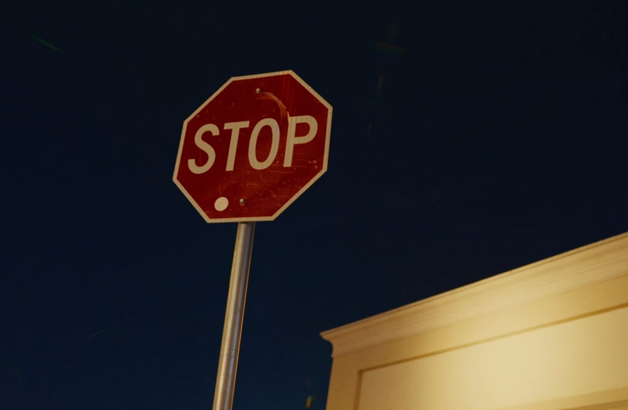 A normal STOP road sign at night outside a store